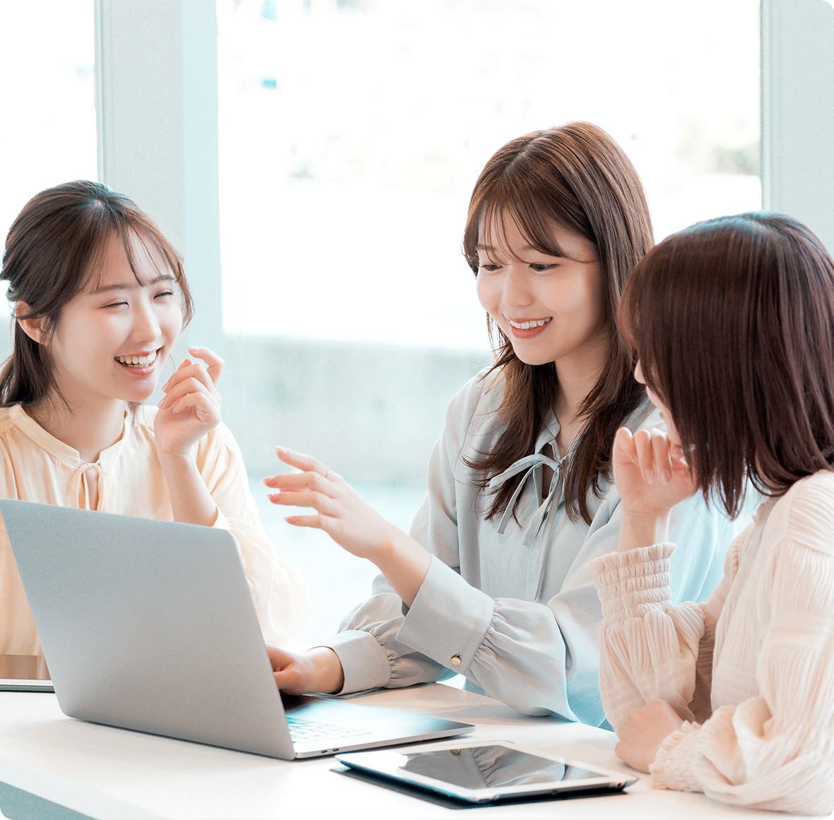女性３人がパソコンを開いて会話している画像